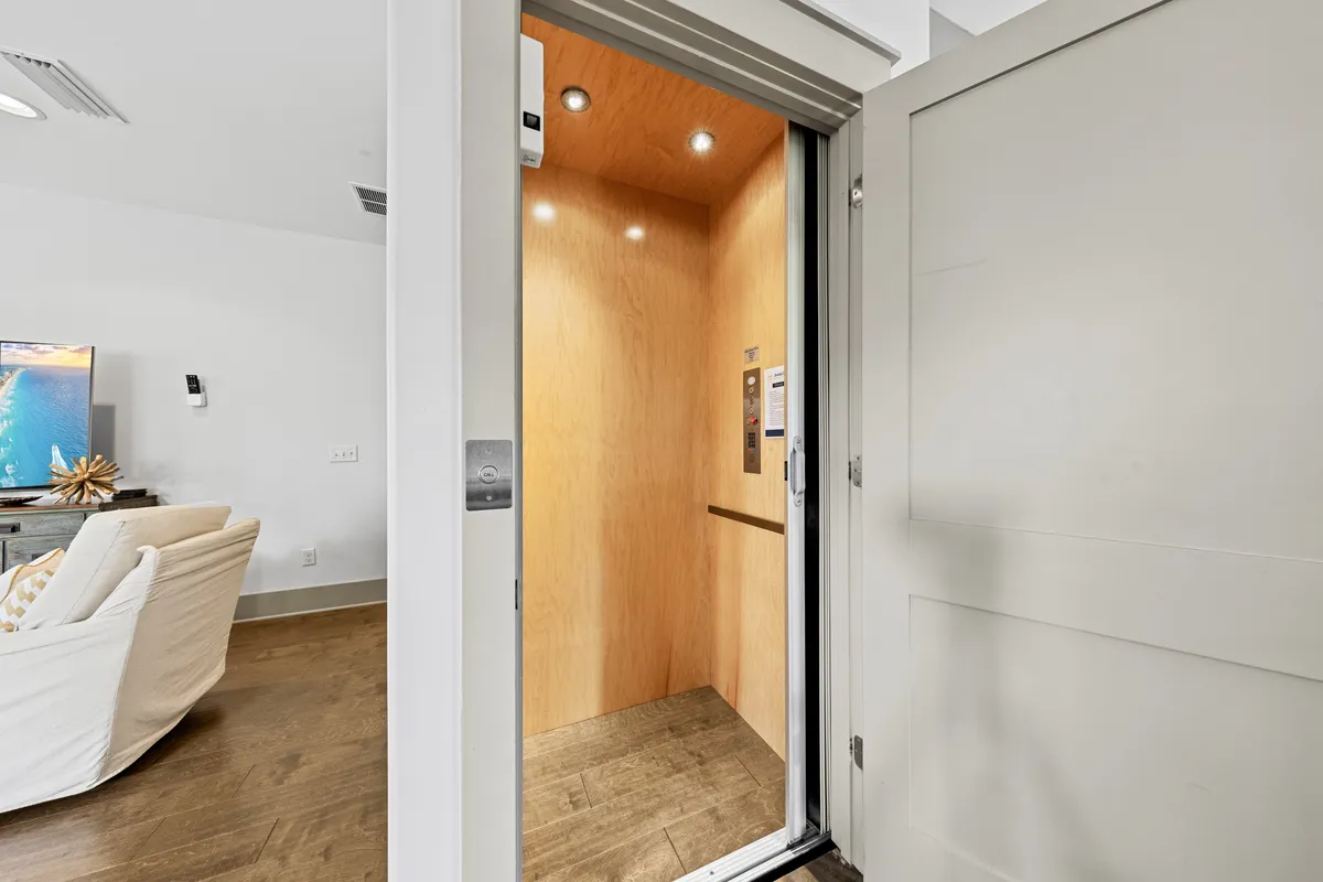 A stylish elevator interior with warm wood paneling and a comfortable built-in seat, reflecting convenience and accessibility for all ages. The space is both functional and inviting.